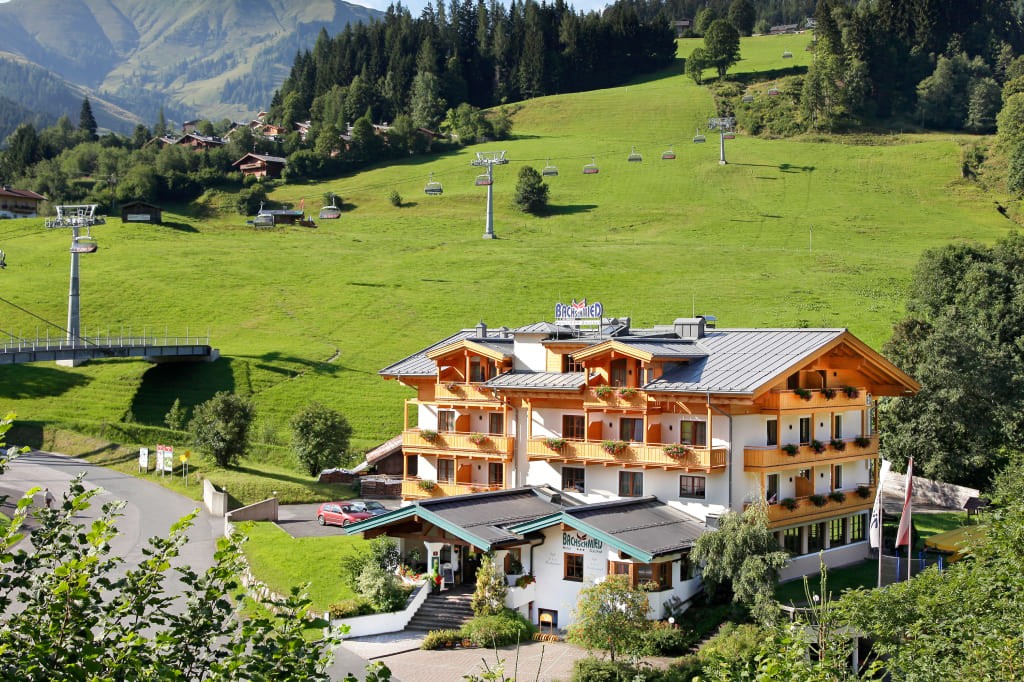 Hotel Bachschmied in Maria Alm vor einer Wiesen- und Berglandschaft
