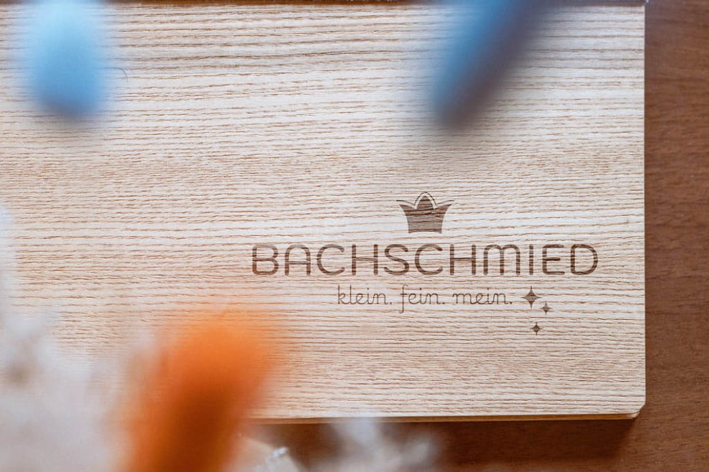 Brett mit dem Logodsign vom Bachschmied Hotel in Maria Alm